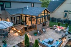 an aerial view of a backyard with patio furniture and lights on the deck, as seen from above