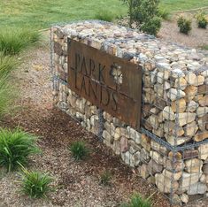 there is a sign that says park lands in front of some grass and rocks on the ground