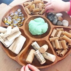 a wooden tray filled with different types of rocks and pastasticks on top of a table