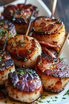 scallops on skewers with sauce and garnish arranged on a plate