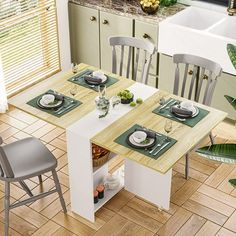 a kitchen table with four chairs and plates on the top, next to a sink