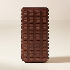 a tall brown vase sitting on top of a white table