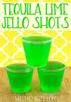 three green jello shots sitting on top of a wooden table