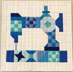 a blue and white quilt with a sewing machine on it