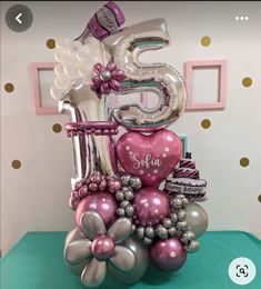 the number five is made out of balloons and other items on top of a table