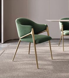 two green chairs sitting next to each other on top of a carpeted floor in front of a white table