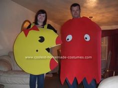 man and woman in costumes standing next to each other holding up large paper cut outs