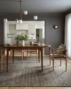 a dining room table and chairs in front of a mirror