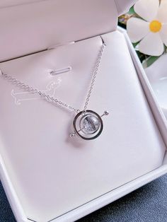 a white box with a silver necklace in it