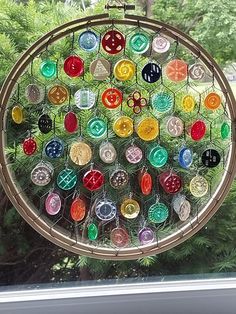 a circular wind catcher with many different colored glass objects hanging from it's sides