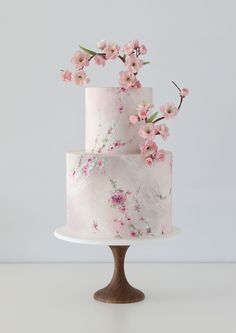 a three tiered cake with pink flowers on top