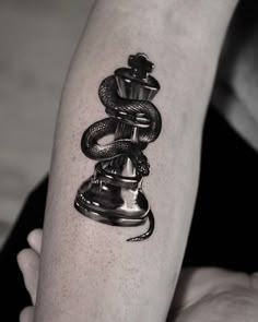 a black and white photo of a person's arm with a snake tattoo on it