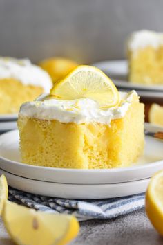 a slice of lemon cake on a plate with the rest of the cake in the background