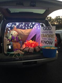 the trunk of a car is decorated with lights and decorations, including a sign that says god loves you smore than you know