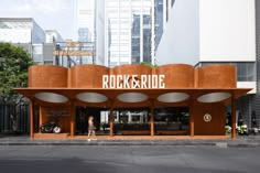 the entrance to rock and ride on a city street with tall buildings in the background