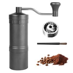 the coffee grinder is next to some spices and cinnamons on a white background