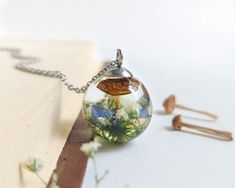 a glass ball with flowers inside sitting on top of a book