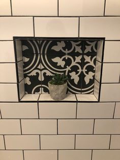 a black and white tiled wall with a potted plant