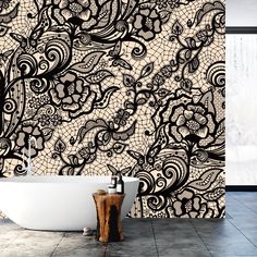 a bath tub sitting next to a wall covered in black and white paisley print fabric