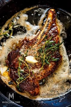 some food is being cooked in a skillet on the stove with gravy