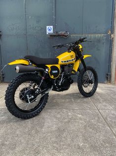 a yellow dirt bike parked in front of a building