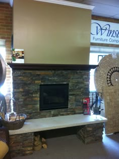 a room with a stone fireplace and furniture in the corner, along with a sign that reads wimsie furniture company