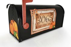 a mailbox decorated with pumpkins and a sign