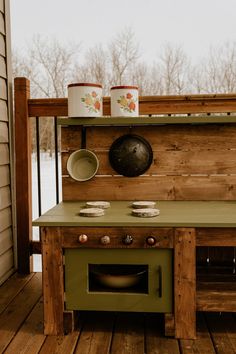 an outdoor kitchen made out of pallet wood with pots and pans on the stove