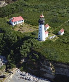 an aerial view of a lighthouse surrounded by trees