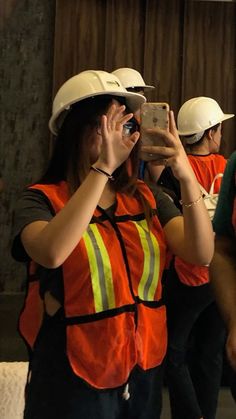 people wearing hard hats and vests taking pictures