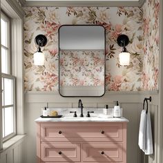 a bathroom with floral wallpaper and pink vanity, two mirrors on the wall above it