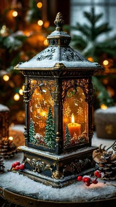 a lighted lantern sitting on top of a table next to christmas trees and pine cones