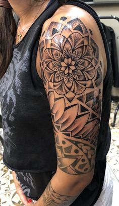 a woman with a black and grey tattoo on her arm