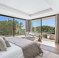 a bedroom with large windows overlooking trees and the ocean is shown in this image from the bed room