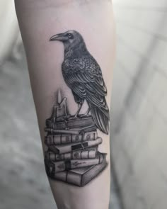 a bird sitting on top of a stack of books