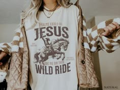 Gear up for your journey with our 'Jesus Guide Me On This Wild Ride' Western Christian T-Shirt. Crafted with comfort in mind, this Coastal Cowgirl Crewneck features a bold graphic print on the front, expressing your faith with style. Whether you're hitting the trails or just embracing the wild ride of life, let this shirt be a testament to your Christian values and your adventurous spirit. Available now to accompany you on every step of your journey. * K E E P * S H O P P I N G *   ✺ Shop our entire Quite Nice Studios collection here: https://www.etsy.com/shop/QuiteNiceStudio * Q U I C K * F A C T S * ✺ 100% preshrunk cotton ✺ Wash (inside out) and dry normally (on cool for best results) * S I Z I N G * ✺ Sizing is unisex so runs like men's, though not overly large ✺ Most women Xfind their Cute Oversized Western Shirts, Cricut Wrangler Shirt, Western T Shirts For Women Simple, Winter Shirts Vinyl Western, Western Cricut Tshirts, Jesus And Country Music Shirt, Western Shirts Vinyl Bohemian, Womens Faith Shirts, Cute Vinyl Shirts Women Christian