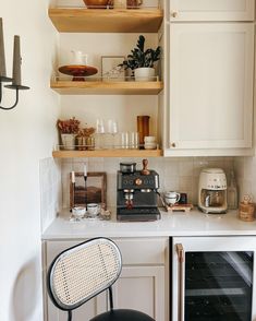 a kitchen with white cabinets and shelves filled with dishes