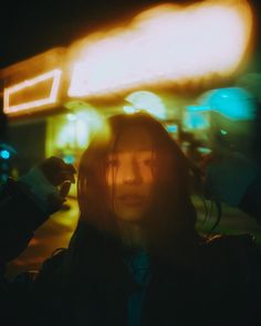 a man with long hair standing in the dark