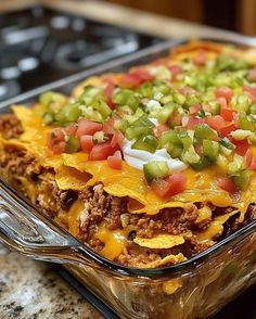 a casserole dish with meat, cheese and vegetables in it sitting on a counter