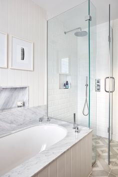 a bathroom with marble counter tops and white tile walls, along with a walk in shower