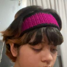 a young boy wearing a pink and black headband