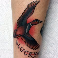 a small tattoo on the leg of a woman with a bird flying above her head