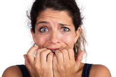 a woman making a funny face with her hands over her mouth while looking at the camera