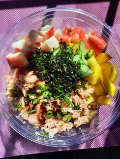 a bowl filled with lots of different types of food on top of a purple cloth