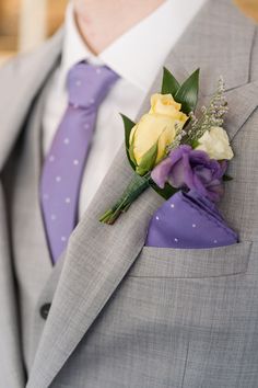 a man wearing a suit and tie with a boutonniere on his lapel