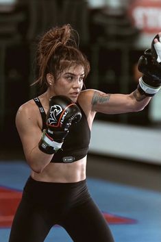 a woman in black boxing outfit and gloves