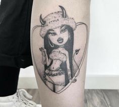 a woman's leg with a tattoo on it and an image of a demon