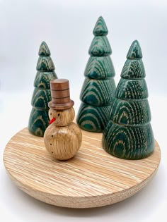 a small wooden snowman sitting on top of a wooden board