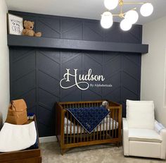 a baby's room with a crib, chair and teddy bear on the wall