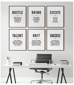 four black and white posters on the wall above a desk with an office chair in front of it